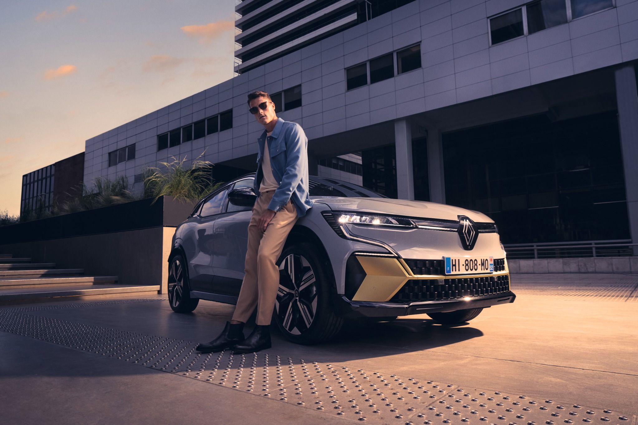 A man leaning against an all new Megane E-Tech 100% electric